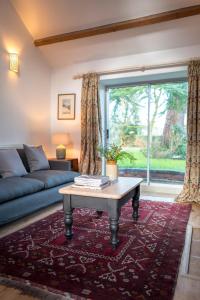 a living room with a couch and a table and a window at Courtyard Cottage in Oswestry