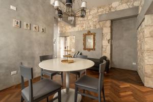 ein Esszimmer mit einem Tisch und Stühlen in der Unterkunft Suite San Tommaso - Ortigia Holidays in Syrakus