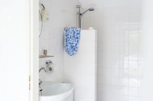 a white bathroom with a sink and a toilet at Holiday home- Bungalow in Loosdrecht