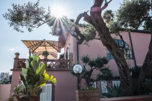 a tree in front of a building with a clock on it at Hotel Villino Gallodoro in Taormina