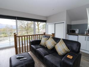 a black leather couch in a living room with a balcony at The Loft in Spean Bridge