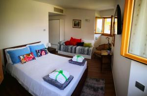 a bedroom with a white bed with colorful pillows at B&B Esmeralda in Arco