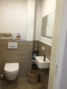 a bathroom with a white toilet and a sink at Ferienwohnung Landblick in Niederlinxweiler +13 photos