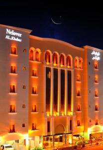 a hotel building with a sign on it at night at Nelover Al Khobar in Al Khobar