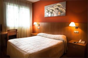 a hotel room with a bed and a window at Hostal RIO SELMO in Ponferrada