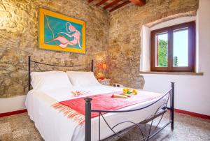 - une chambre avec un lit dans un mur en pierre dans l'établissement Casetta de Sodoni, à Pomaia