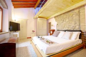 um quarto com uma cama grande e uma parede de pedra em Casetta de Sodoni em Pomaia
