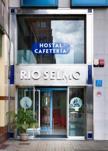 a building with a sign for a hospital cafeteria at Hostal RIO SELMO in Ponferrada