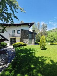 a house with a green lawn in front of it at Villa Sendy Sarajevo in Sarajevo