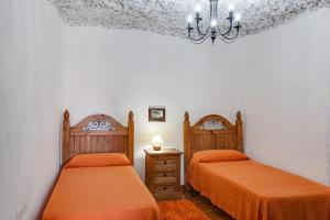 a bedroom with two beds and a chandelier at Casa Chinamada in Las Lagunas