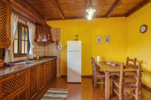 a kitchen with a table and a white refrigerator at Casa Chinamada in Las Lagunas