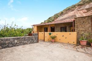 a house with a stone wall in front of it at Casa Chinamada in Las Lagunas