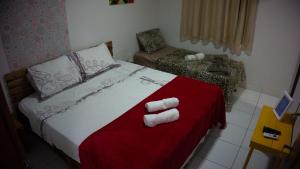 a bedroom with a bed with towels on it at Pousada Viana in Garanhuns