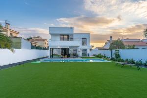 a white house with a large yard with a green lawn at Villa swimming pool Malaga in Rincón de la Victoria