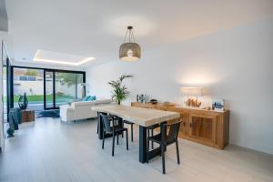 eine Küche und ein Wohnzimmer mit Tisch und Stühlen in der Unterkunft VillaSwimmingpoolMalaga in Rincón de la Victoria