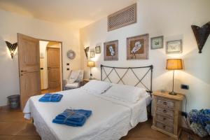 a bedroom with a bed with two blue towels on it at Villa Hortensia in Arzachena