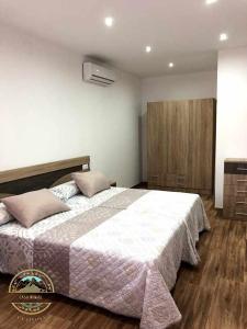 1 dormitorio con 1 cama grande y suelo de madera en Alojamiento Rural La Tiñosa, en Las Lagunillas