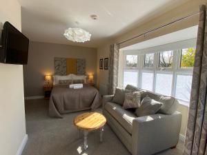 a living room with a couch and a bed at Carlton Corner Bed & Breakfast in Kibworth Harcourt