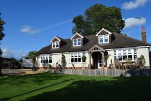 a white house with a black roof at Carlton Corner Bed & Breakfast in Kibworth Harcourt