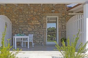 Casa de piedra con mesa y ventana en La Littighedda, en Rena Majore