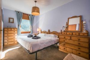 una camera da letto con un letto grande e uno specchio di Bonaigua 409 by SeaMount Rentals a Baqueira-Beret