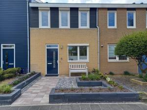 a house with a bench in front of it at Vakantiehuis, Kaaidijk 42 Kortgene in Kortgene