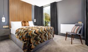 a bedroom with a bed and a chair and a window at Sweden Lodge - wonderful property in Ambleside in Ambleside +30 photos