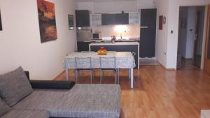 a living room with a table and chairs and a kitchen at Lorena app in Umag