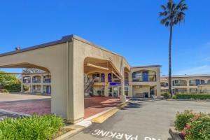 un bâtiment avec un palmier en face dans l'établissement Motel 6-Lodi, CA, à Lodi