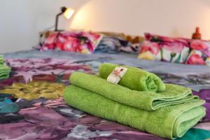 un asciugamano verde seduto sopra un letto di Sunshine home attico vista mare ad Alghero