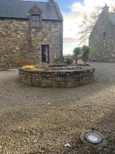 un edificio de piedra con un jardín delante de él en Clós Na Feirme, en Galway