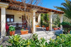 Klisma Beach House في سكالا كاليراخيس: منزل مع شرفة مع نباتات الفخار