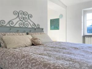 a bedroom with a large bed with a silver headboard at Le case della Lizza - Casa Rossa in Levanto