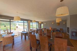 un comedor con mesas, sillas y ventanas en Quinta Tapada Do Gramacho, en Silves