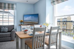 a dining room with a table and chairs and a television at Abbey Road Boutique Holiday Apartment in Llandudno