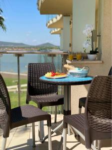 a table with a plate of food on a balcony at Laura apartman Velence in Velence