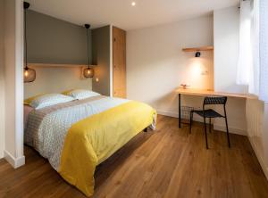 een slaapkamer met een bed, een bureau en een tafel bij Maloca' Robretières in La Roche-sur-Yon