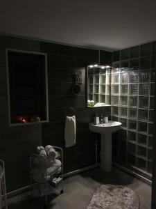a black bathroom with a sink and a mirror at CASA MADAME COCO in Piatra