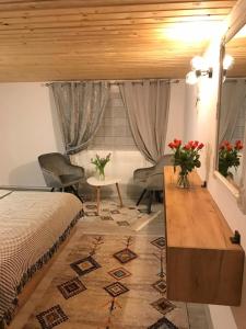 1 dormitorio con 1 cama y 1 mesa con flores en CASA MADAME COCO, en Piatra