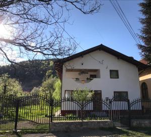 a white house with a black fence at CASA MADAME COCO in Piatra