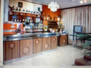a kitchen with a counter and a table and chairs at HOTEL ROSSINI in Rimini