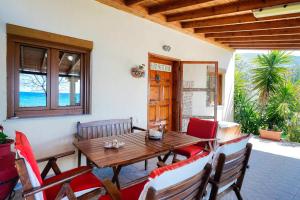 Klisma Beach House في سكالا كاليراخيس: غرفة طعام مع طاولة وكراسي خشبية