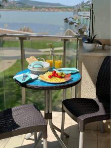 a table with a plate of food on a balcony at Laura apartman Velence in Velence