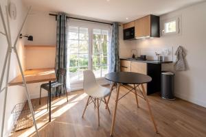 - une cuisine avec une table et des chaises dans la chambre dans l'établissement Maloca' Robretières, à La Roche-sur-Yon