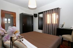 Un dormitorio con una cama y una silla y una ventana. en Douro House, en Tabuaço