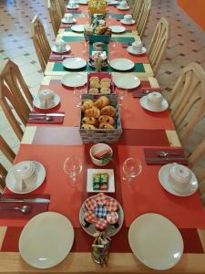 uma mesa longa com pratos e tigelas de comida em Hôtel Les Rives D'Allier em Reilhac
