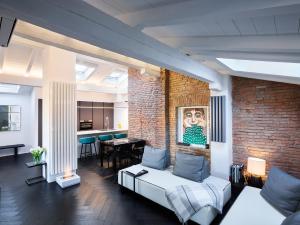 a living room with a brick wall and a couch at OBERDAN SUITE Appartamento nel cuore di Bologna in Bologna