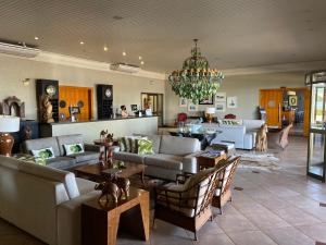 a living room with couches and a chandelier at Hotel OT in Três Lagoas