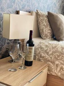 a bottle of wine and two glasses on a table at Lake and Spa Apartman in Velence