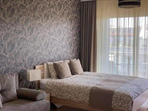 a bedroom with a bed and a window and a couch at Lake and Spa Apartman in Velence